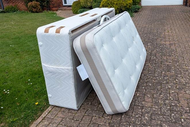 mattress being loaded onto a truck for removal